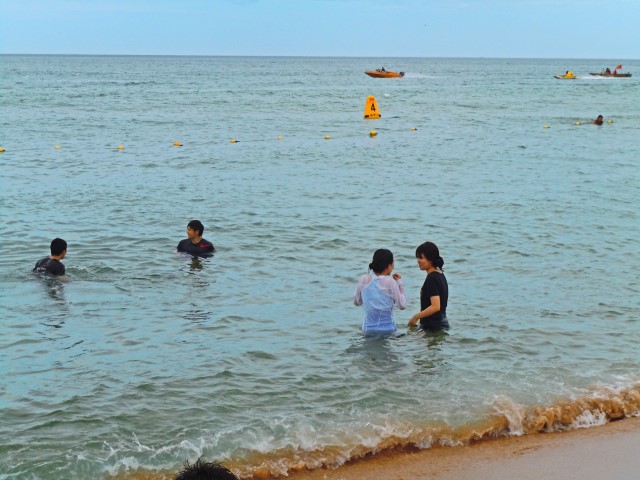 Alle baden mit ihrer Kleidung im Meer auf Jeju, Südkorea