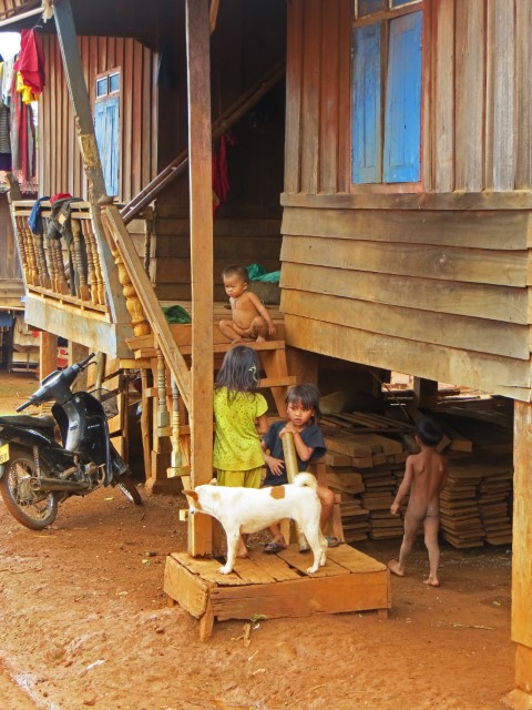 Holzhütte mit davor spielenden Kindern auf dem Bolaven Plateau Laos