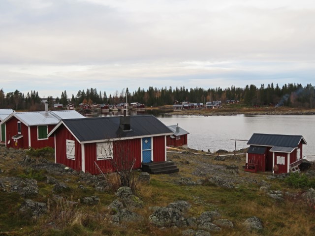 Rote Holzhäuser auf einer Insel in Nordschweden