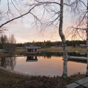 Abendlicht am See in Schweden mit rotem Holzhaus