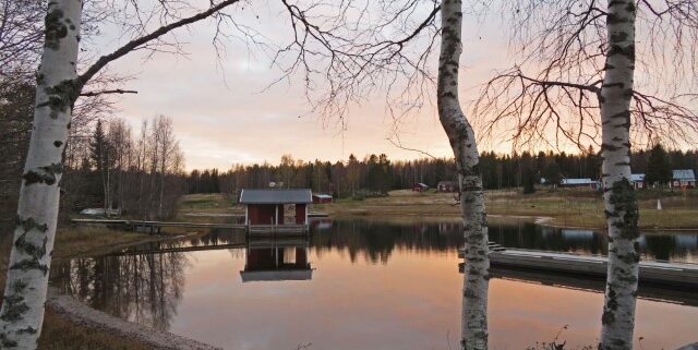 Abendlicht am See in Schweden mit rotem Holzhaus